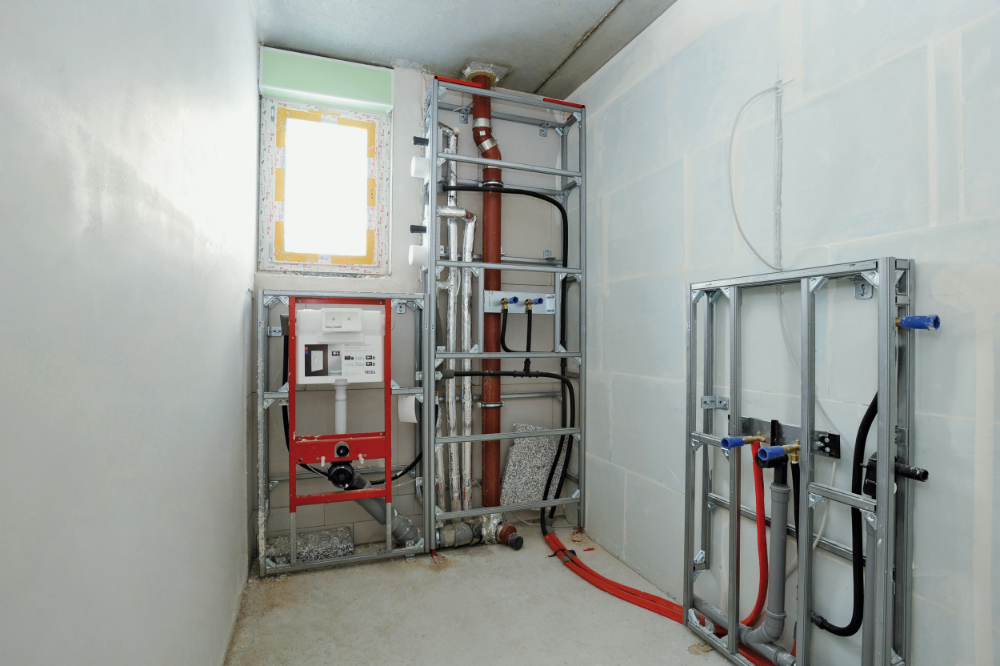 Als er leidingen naast het toilet lopen, kan het aangewezen zijn om de volledige muur af te werken met profielen en plaatmateriaal